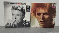Front covers of ChangesOneBowie and Space Oddity David Bowie albums side by side on table.