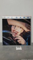 Front cover of The Cars LP album, featuring a woman's face and hand partially covering it.