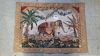 Full view of the tapestry showing the central elephant, surrounding plants, and ornate border