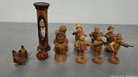 Full view of all 11 wooden items including sand timer, two angel figurines, six musicians, a dog, and a squirrel figurine, showing size and details