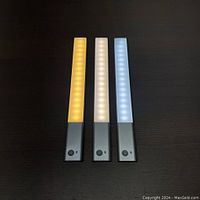 Three LED strip lights arranged side by side showing warm, natural, and cool light modes active.