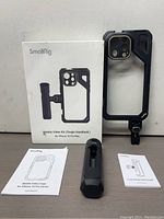 Overall kit including box, cage, handle, and user manuals laid out on a flat surface.