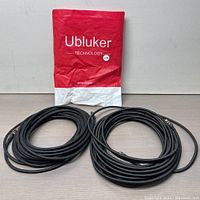 Photo showing two coiled black HDMI cables and red Ubluker branded packaging in background.