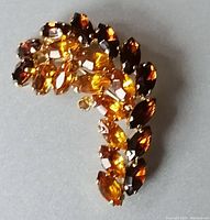 Front view showing amber-colored rhinestones arranged in floral arched design with varied stone cuts.