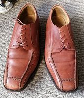 Top view of the pair of brown leather lace-up shoes with square toe design showing stitching details.