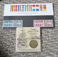Set of Royal Mail mint stamps commemorating the 25th Anniversary of the Second European Election 1984 featuring colorful flag designs, and a Captain James Cook Bicentennial Commemorative Medallion in original display card showing ship and text.
