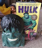 Front and side photos of The Incredible Hulk green mask with black hair and original box in background.