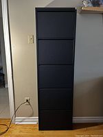 Front view of closed 5 tier anthracite metal shoe cabinet against wall on wood floor.