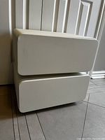 White Bubble Nightstand with two drawers shown from front angle. Minor corner damage visible.