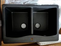 Top view of KRAUS Forteza black granite composite double bowl kitchen sink showing two equal bowls and central faucet hole.