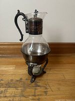 Full assembled carafe on silver plated stand with candle warmer and silver lid in place