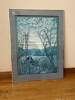 Front view of framed poster print featuring blue and teal floral design with magnolia and iris flowers and scenic background.