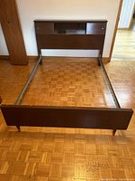 Full view of the bed frame assembled, showing the headboard and footboard connected by metal side rails.