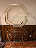Front view of the stacked octagonal metal and glass shelves showing two octagonal frames with glass shelves inside.