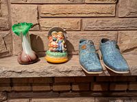 Full lot showing the small glass vase, children figurine, and two ceramic shoe figurines