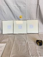 Three square silver picture frames displayed side-by-side showing their fronts with white insert cards.