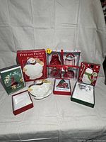 Lot contents arranged on white backdrop with several holiday-themed items including Fitz & Floyd ceramic dish and boxed cards