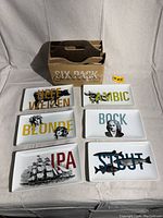 Photo showing all six Crate & Barrel appetizer plates spread out with a cardboard six-pack holder behind them.