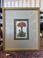 Full view of the large framed print showing gold outer frame with textured diagonal stripes and large beige mat.