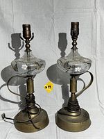 Pair of vintage brass and crackle glass lamps shown side by side with visible wiring and brass bases.
