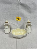 Photo showing two Belleek porcelain girl figurines and one small scalloped bowl together