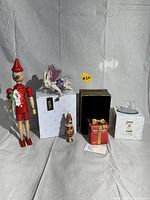 Group photo of vintage gift and ornament lot including Pinocchio figure, fairy ornament, present ornament, egg ornament, and small figurine