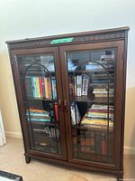 Front view of dark wooden bookcase filled with books