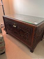 Photo of the full chest showing the detailed carvings and glass top.