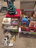 Overview of assortment showing three boxes with various Christmas angel figurines, decorations, and ceramic Christmas tree parts.