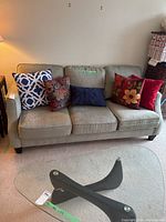 Front view of the Sklar Peppler couch with six decorative cushions, showing seat cushions and arm shape.