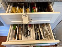 Top drawer showing yellow handled cutlery and some black handled utensils