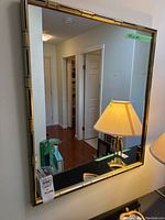Rectangular bamboo look framed mirror reflecting hallway, with tag 'lamp + mirror'