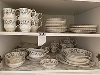 Stack of eight dessert plates with scalloped edge and gold accent