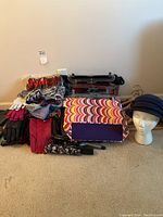 Full view of scarves, gloves, colorful handbag, umbrella, and navy wool hat on mannequin head