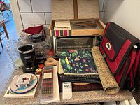 Photo showing various kitchen items including blender, placemats, cooler bag, cutting board, and other accessories arranged on a table