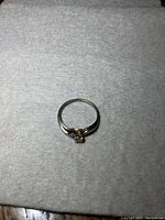 Top view of vintage 10K gold solitaire diamond ring on gray fabric, showing overall design.