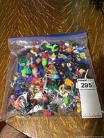 Large ziplock bag filled with assorted building block figures and accessories from above view.