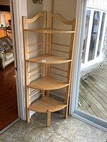 Front view of the solid wood corner shelf with five triangular shelves, showing overall structure and design.