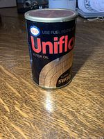 Photo of a cylindrical radio designed as an Esso Uniflo motor oil can showing front label details with logo and product text.