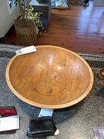 Top view of the large wooden bowl placed on a counter, showing interior wear marks and wood grain.