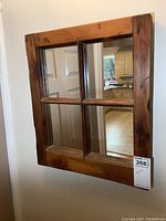 Front view of the wooden framed window mirror showing four mirror panes inside the frame.