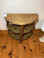 Side view of vintage wooden side table showing top and two shelves with beveled edges and solid wood construction.