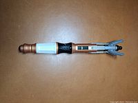 Top view of the metallic Doctor Who sonic screwdriver replica with extended claws.