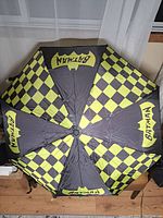 Top view of open umbrella showing checkered black and yellow panels and Batman logos.