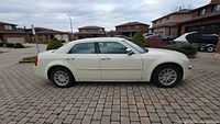 Side profile view of white Chrysler 300 showing four doors, alloy wheels and body finish