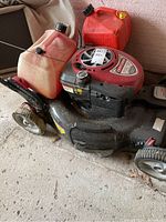 Side view of the Craftsman lawn mower with the engine and jerry cans visible