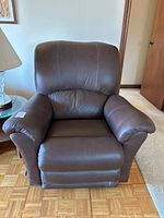 Front view of brown leather recliner in upright position