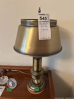 Full view of MCM brushed brass table lamp with shade, tags attached indicating details and lot number.