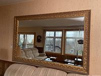 Full frontal view of the mirror showing its size relative to the sofa and windows in the background.