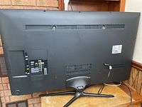 Back of TV showing stand, ports and overall condition